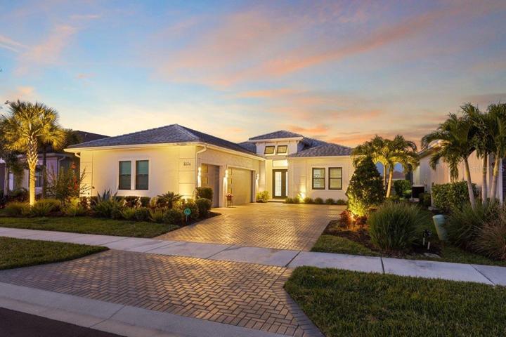 Front Elevation showing the extensive landscape lighting, huge paver driveway, and 23'x30' garage.