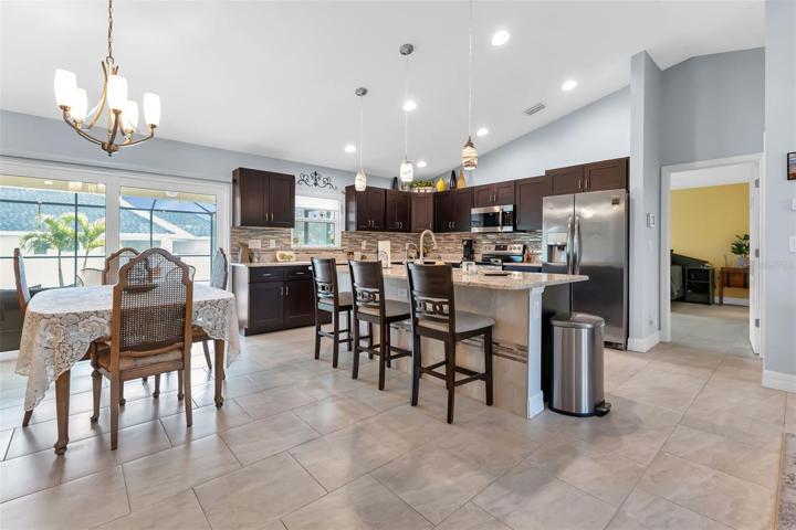 Beautiful kitchen with island, granite countertop, tile backsplash, and plenty of cabinets.