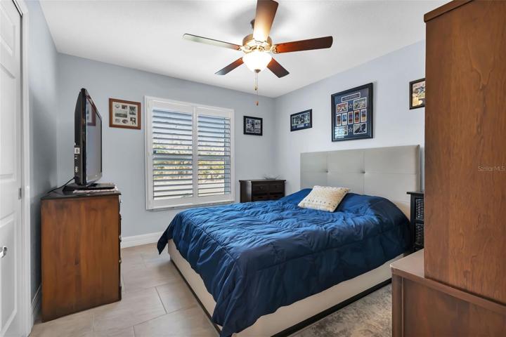 2nd Guest bedroom with porcelain tile, closet and plantation shutters.