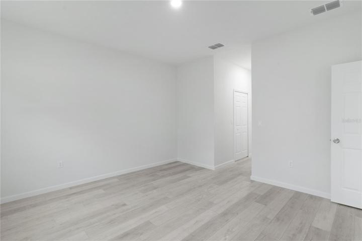 Primary bedroom door is to the right, looking towards his/hers walk-in closets, with primary bathroom beyond
