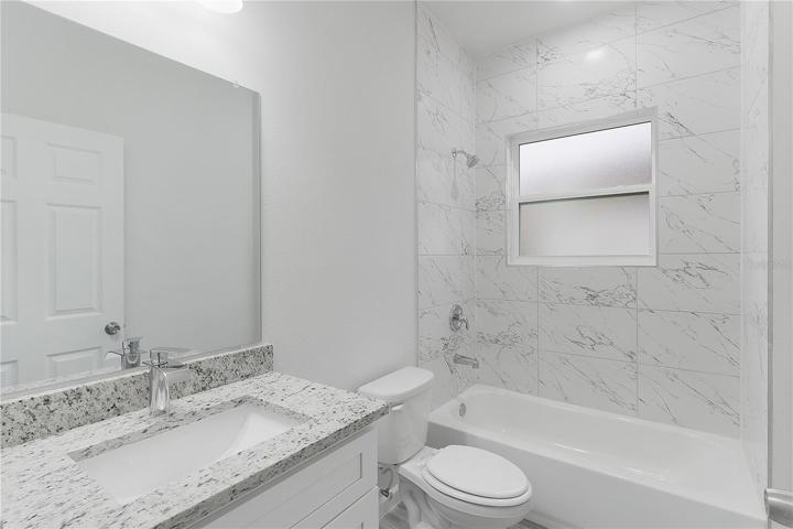 Guest bathroom with tile surround and granite countertop
