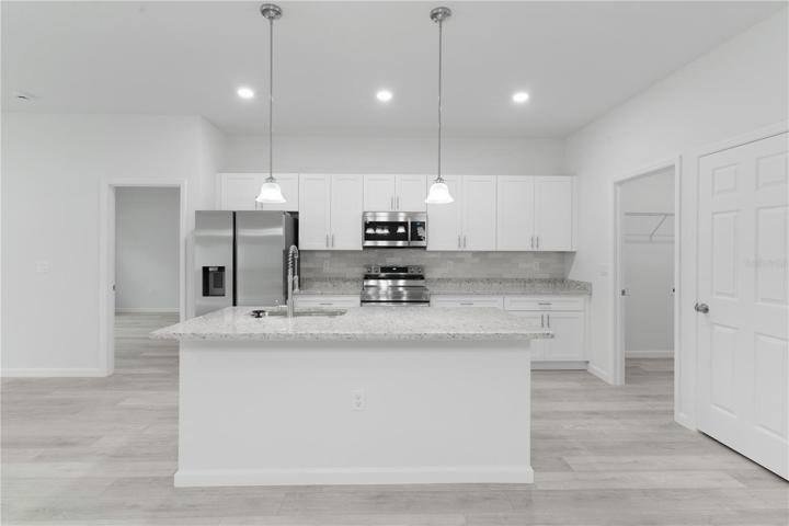 Kitchen island with sink, breakfast bar, and large food prep area