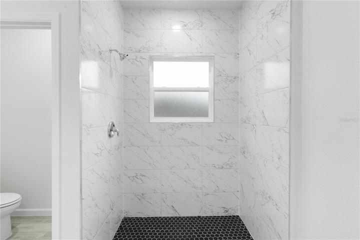 Walk-in tiled shower, with private toilet room to the left