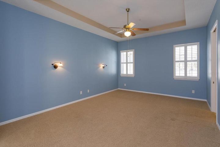 Master bedroom that is expansive, has a tray ceiling and double french doors that open to the backyard patio.
