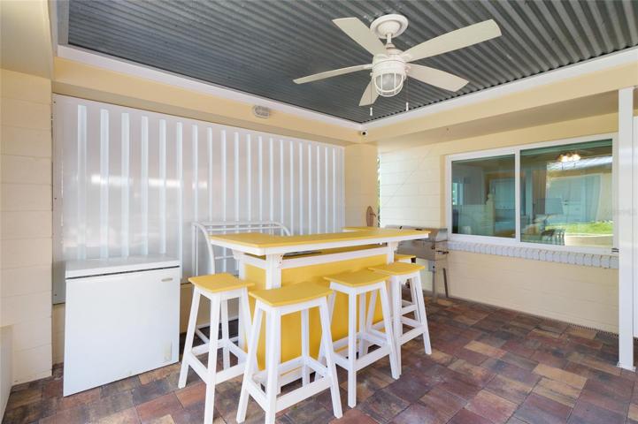Covered back porch complete with ice chest, commercial ice maker, bar, and ping pong table!
