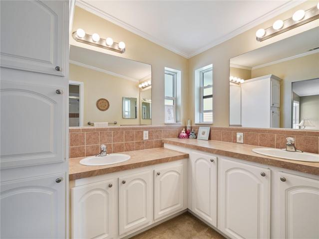 Ensuite bathroom has dual sinks and lots of cabinets and counter space.