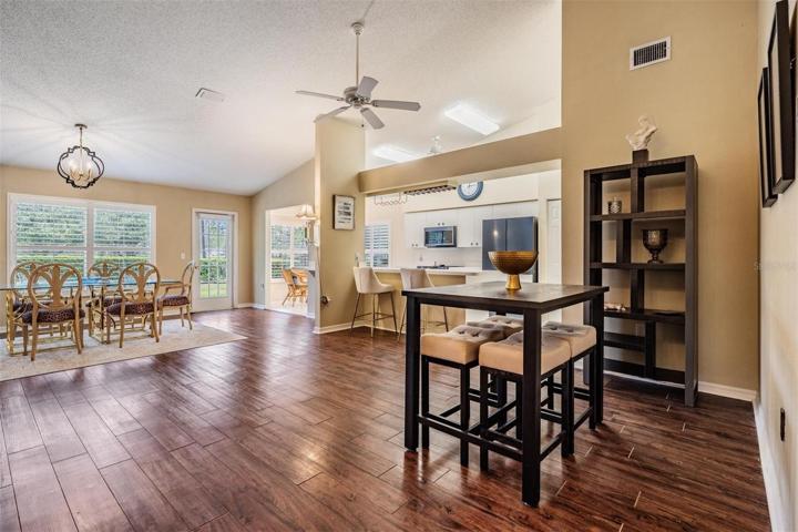 Bar/dining area with view of kitchen and a bright and sunny bonus area