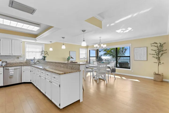 Kitchen with stainless steel appliances, ceramic tiles with wood look.