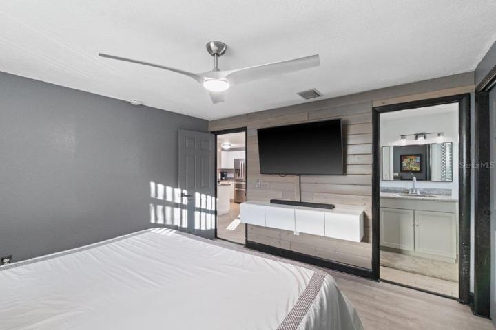 Primary bedroom featuring a ensuite bathroom, walk-in showing, and ample cabinetry.