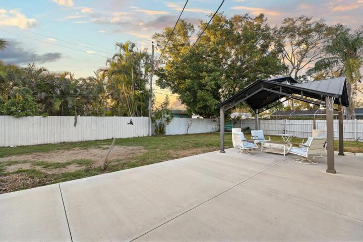 Spacious fenced-in back yard featuring a newly built concrete patio, gazebo, and firepit!