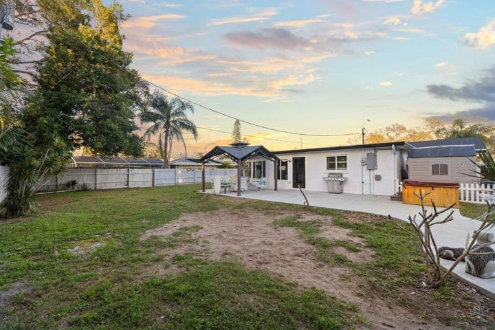 Spacious fenced-in back yard featuring a newly built concrete patio, gazebo, and firepit!