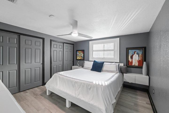 Primary bedroom featuring a ensuite bathroom, walk-in showing, and ample cabinetry.