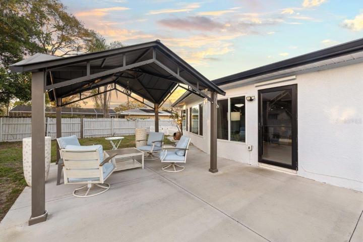 Spacious fenced-in back yard featuring a newly built concrete patio, gazebo, and firepit!