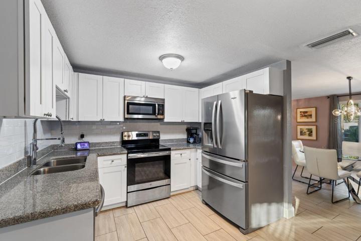 Kitchen featuring granite countertops, stainless steel appliances, and a coffee bar.
