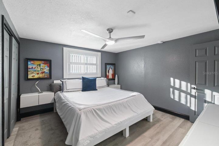 Primary bedroom featuring a ensuite bathroom, walk-in showing, and ample cabinetry.