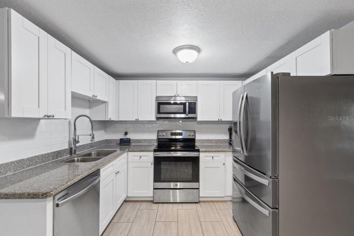 Kitchen featuring granite countertops, stainless steel appliances, and a coffee bar.