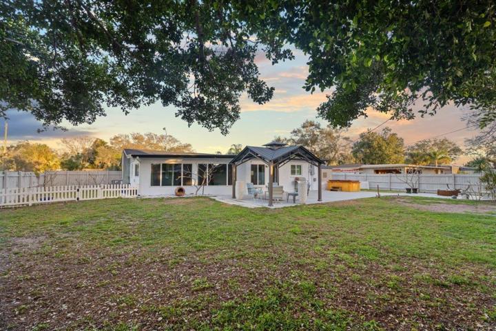 Spacious fenced-in back yard featuring a newly built concrete patio, gazebo, and firepit!