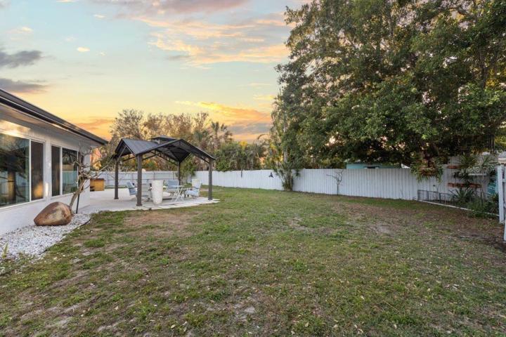 Spacious fenced-in back yard featuring a newly built concrete patio, gazebo, and firepit!