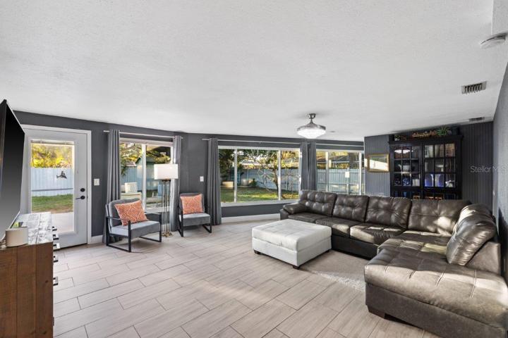 Living Room featuring impact windows, a nook perfect for a home office or library, and views of your backyard.