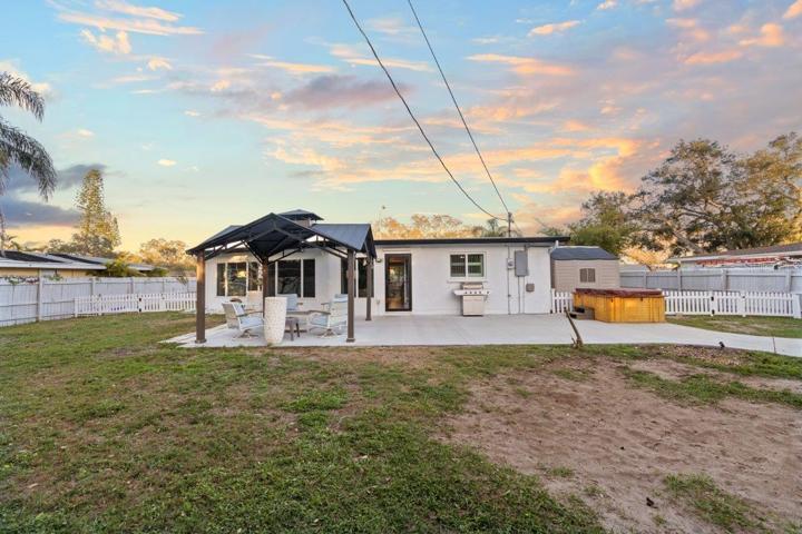 Spacious fenced-in back yard featuring a newly built concrete patio, gazebo, and firepit!