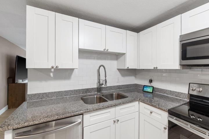 Kitchen featuring granite countertops, stainless steel appliances, and a coffee bar.