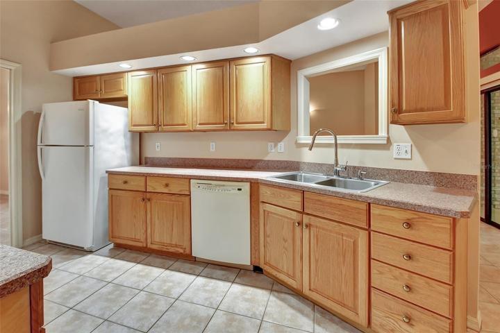 Kitchen refrigerator and dishwasher with pass through window