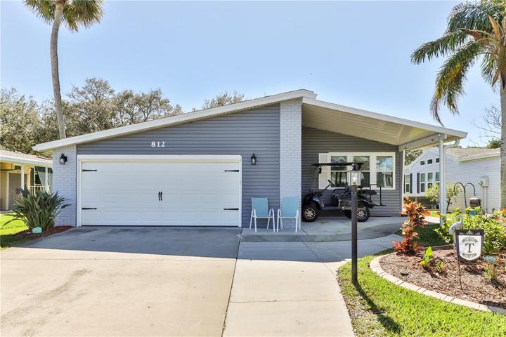 Front view with 2 stall garage and covered golf cart pad.