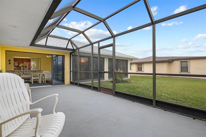 The caged in lanai overlooks the green space.