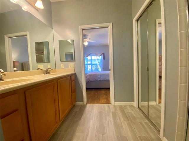 Master bathroom with double vanity and pocket door into bedroom