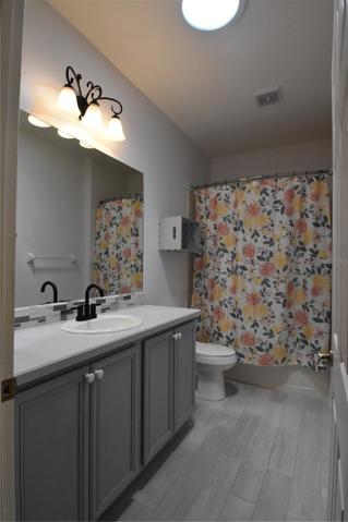 Guest bathroom with raised vanity and tile surround shower