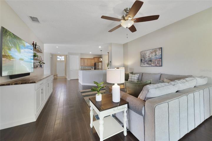 The large living area is next, complete with a CUSTOM BUILT-IN and TRIPLE SLIDING GLASS DOORS out the SCREENED LANAI for indoor/outdoor living at its finest!