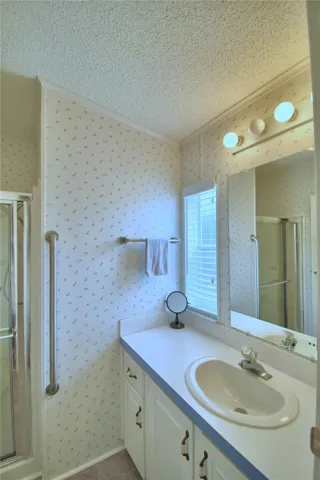 The ensuite bathroom has a shower stall.