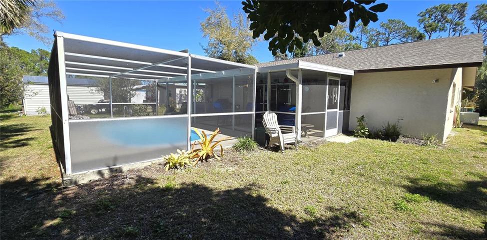 Backyard view of screened pool enclosure