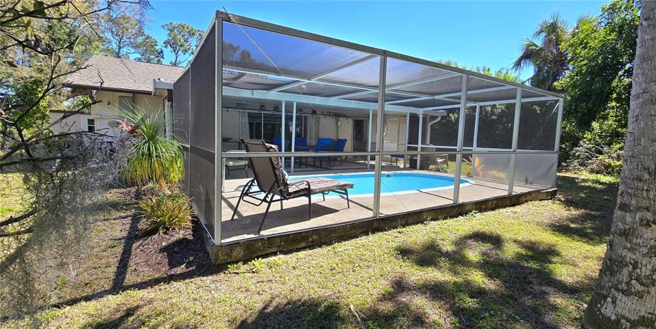 Backyard view of screened pool enclosure