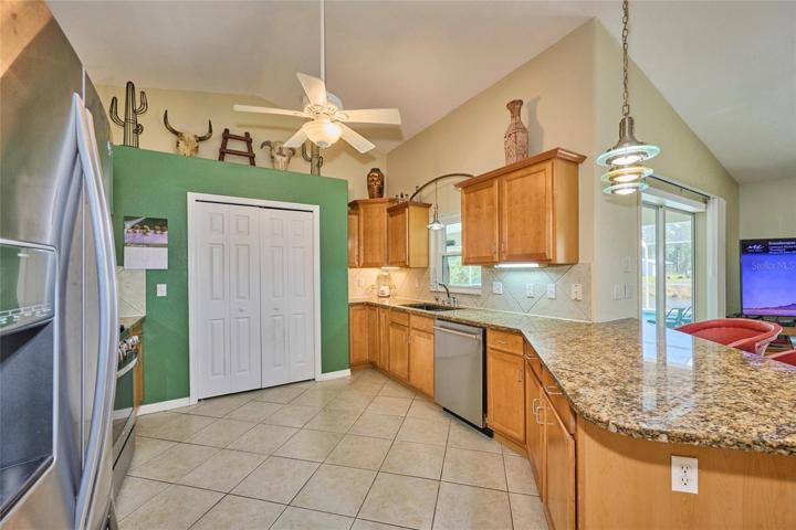 Kitchen has lots of cabinetry and counter space and nice-size pantry (doors in back of picture)