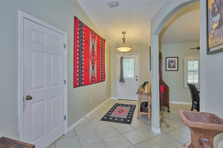 View of front door entrance and peek into dining room.  Door to left opens into laundry room.