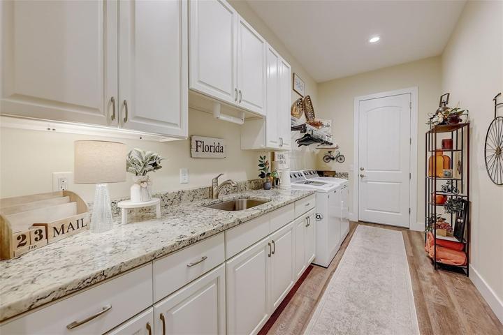Laundry room with hand sink and extra cabinets for storage