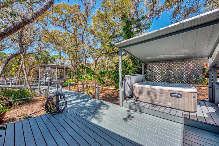 Deck showing covered hot tub, with the Zen Den (gazebo) down the boardwalk