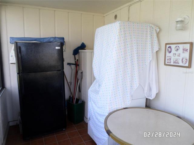 Back porch with full size refrigerator and stack washer/dryer