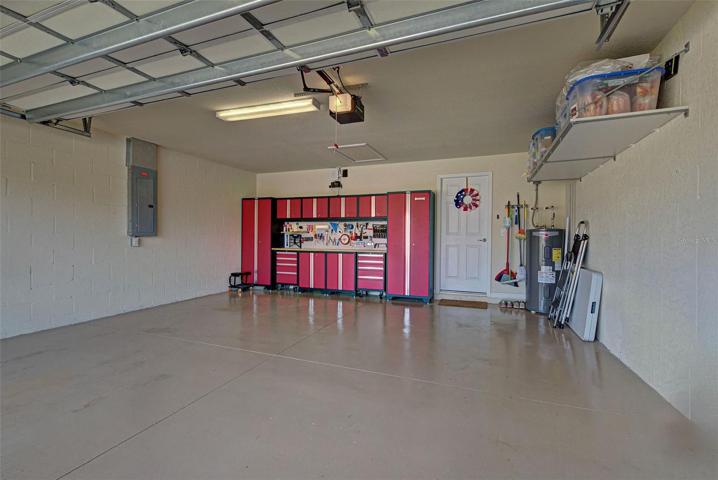 Immaculate garage with added shelves on one side as well as built-in work bench and cabinets with plenty of room to store all your tools.