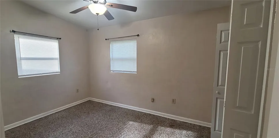 Bedroom 1 with double closet, tall ceilingsterrazzo floors and view to the back yard