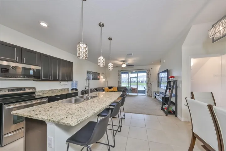 Sparkling clean kitchen boasts of Granite countertops, contemporary coffee colored cabinets and lights along with all new appliances and a breakfast bar.