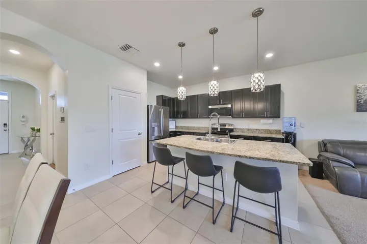 Plenty of seating at the open breakfast bar with a large walk-in pantry to the left.