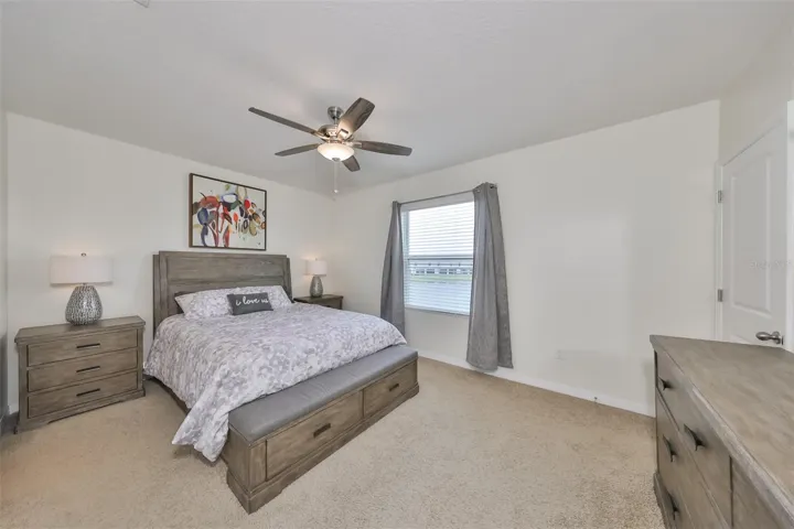 Primary bedroom is large, with NEW Carpet and relaxing neutral colors and a large window for natural light and a water view.