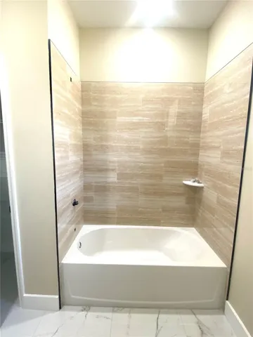 hall bath with tiled tub/shower combo