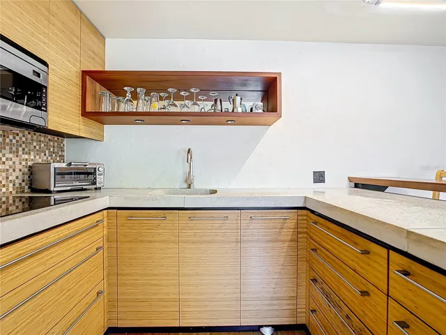 Nice sleek designed kitchenette. Drop in stove top. Built in microwave. Where is the Fridge & Freezer?!!! To your right; drawer style. Next picture will show you.