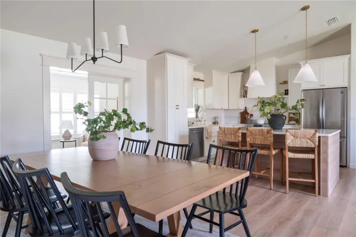 Joining the living room with the kitchen is a dining area.  Beyond the elegant French doors lies the den/family room