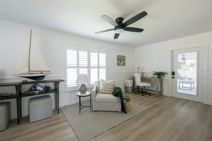 Plantation shutters, a remote-controlled fan, ship lap walls adorns the lower portion of the walls and an abundance of natural light.