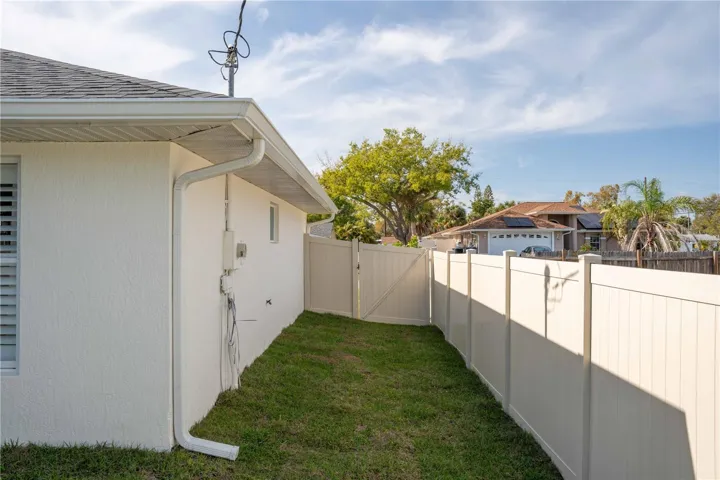 The entire home has vinyl fencing with wide gates on each side