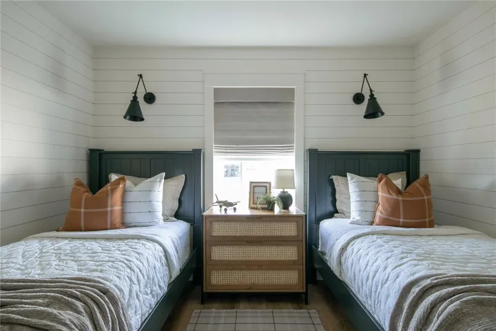 The 2nd bedroom features custom-made Roman shade, wireless remote-controlled sconces, 6 in classic ship lap, and a Pax closet with pullout drawers.